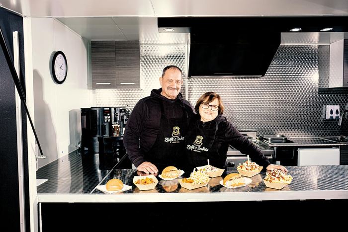 Meryem und Agop Zülfikaroglu in ihrem Foodtruck, vor sich frisch zubereitete Portionen auf dem Tresen